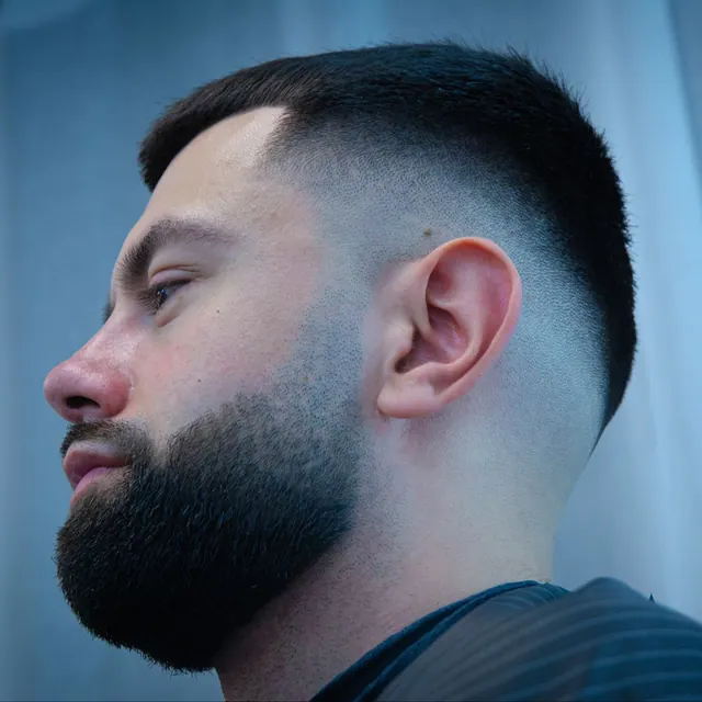 A skin fade with a full beard